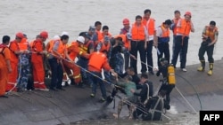 Une femme de 65 ans, au centre, secourue par des plongeurs du navire Dongfangzhixing ("Etoile de l'Orient") qui a fait naufrage dans le fleuve Yangtsé à Jianli, dans la province Hubei, Chine le 2 juin 2015