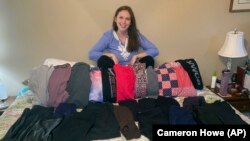 This photo shows Cameron Howe at home in Lynchburg, Va., on June 28, 2021, with her collection of leggings she bought during the pandemic. She hopes to continue wearing leggings as business clothing as she goes back to work. (Cameron Howe via AP)