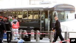 Police officers investigate the crime scene after a gunman fired shots at US soldiers on the bus outside Frankfurt airport, Germany, killing two airmen and wounding two before being taken into custody, March 2, 2011