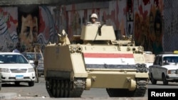 FILE - A soldier stands guard in a tank in Tahrir square in Cairo, Egypt. 