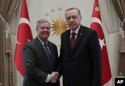 Turkey's President Recep Tayyip Erdogan, right, and U.S. Republican Senator Lindsey Graham shake hands before a meeting in Ankara, Turkey, Jan. 18, 2019.