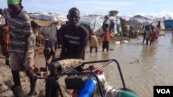 Aid workers run pump to combat floodwaters that have submerged homes at camp for displaced people, Bentiu, South Sudan (G. Joselow/VOA).