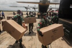 Para anggota TNI membantu distribusi peralatan medis ke sejumlah rumah sakit di tengah wabah virus corona, di Bandara Tjilik Riwut, Kalimantan Tengah, 4 April 2020. (Foto: Antara via Reuters)