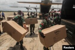 Para anggota TNI membantu distribusi peralatan medis ke sejumlah rumah sakit di tengah wabah virus corona, di Bandara Tjilik Riwut, Kalimantan Tengah, 4 April 2020. (Foto: Antara via Reuters)