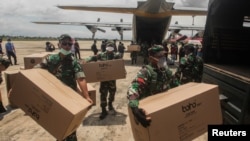 Para anggota TNI membantu distribusi peralatan medis ke sejumlah rumah sakit di tengah wabah virus corona, di Bandara Tjilik Riwut, Kalimantan Tengah, 4 April 2020. (Foto: Antara via Reuters)