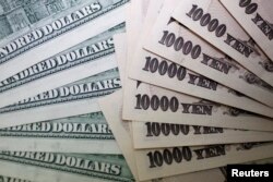 Uang kertas 10.000 yen Jepang di sebelah uang kertas 100 dolar AS di Interbank Inc. di Tokyo. (Foto: REUTERS/Yuriko Nakao)