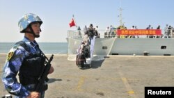 一名中国海军站在也门亚丁港口的海军护卫舰临沂号旁(资料照片)