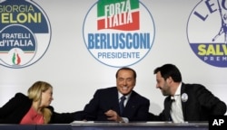 FILE - From left, Brothers of Italy's Giorgia Meloni, Forza Italia's Silvio Berlusconi, and the League's Matteo Salvini attend a media event for center-right leaders ahead of the March 4 general elections, in Rome, Italy, March 1, 2018.