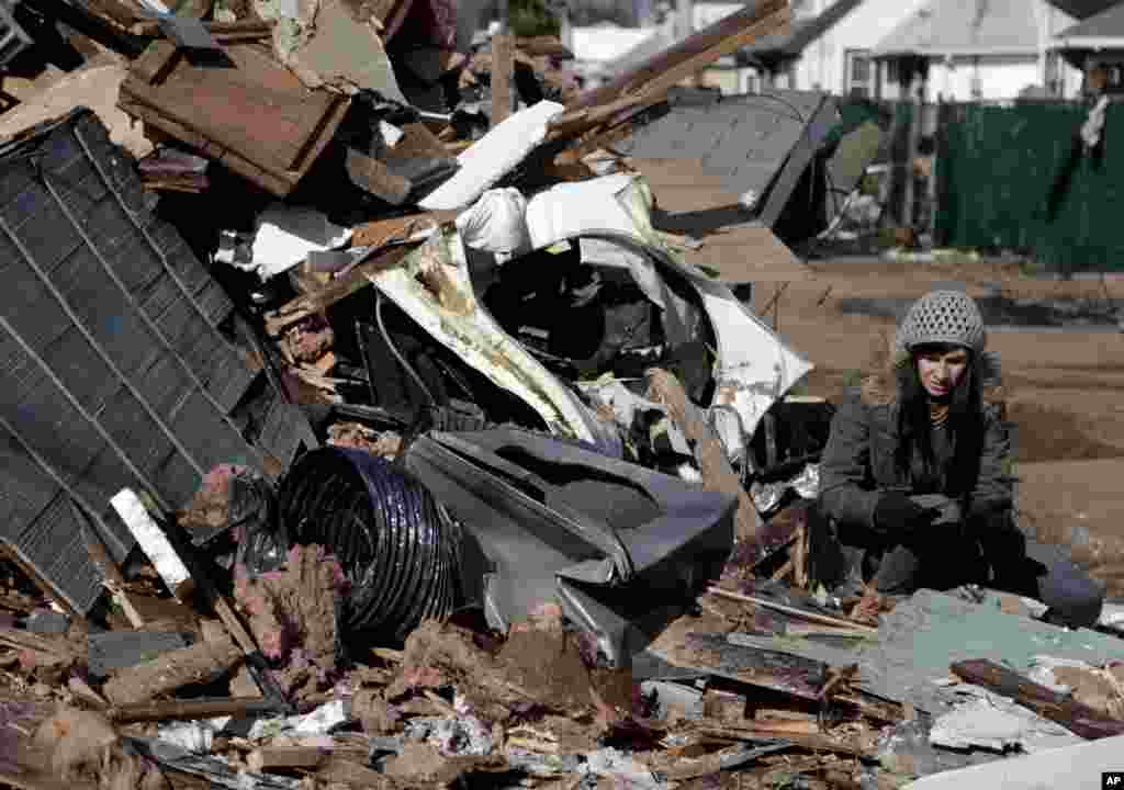 Julie Traina tries to recover some personal items from the destroyed home of her parents in the Staten Island borough of New York, November 2, 2012.