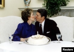 President Ronald Reagan and his wife Nancy kiss on their wedding anniversary in the White House March 4 1985.