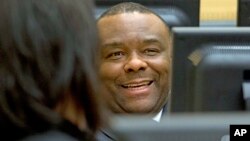 FILE - Former Congo vice president Jean-Pierre Bemba smiles while waiting for the start of his trial, at the International Criminal Court in The Hague, Netherlands, Nov. 27, 2013.