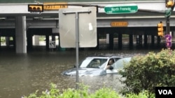 Floodwaters threaten to swallow a vehicle stranded on Interstate 45-North Freeway in Houston, Texas, Aug. 27, 2017. (C. Mendoza/VOA). 