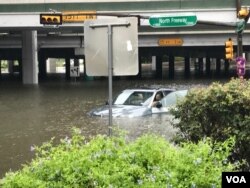 Floodwaters threaten to swallow a vehicle stranded on Interstate 45-North Freeway in Houston, Texas, Aug. 27, 2017. (C. Mendoza/VOA).
