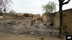 Cette photo prise avec un téléphone portable montre une jeune fille sur les ruines des maisons incendiées à Baga (21 avril 2013) 