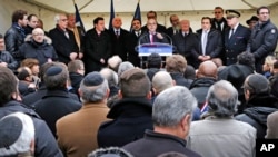 FILE - French Interior Minister Bernard Cazeneuve, center, speaks at a gathering against anti-Semitism also attended by Israel's ambassador to France, Yossi Gal, left, in Creteil, east of Paris, Dec. 7, 2014.