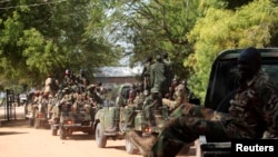 South Sudan army soldiers hold their weapons as they ride on a truck in Bor, Dec. 25, 2013. 