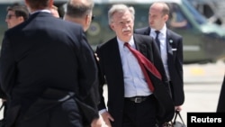 U.S. President Donald Trump's National Security Adviser John Bolton carries a bag as he arrives to board Air Force One to depart for travel to Singapore from Quebec, Canada, June 9, 2018.