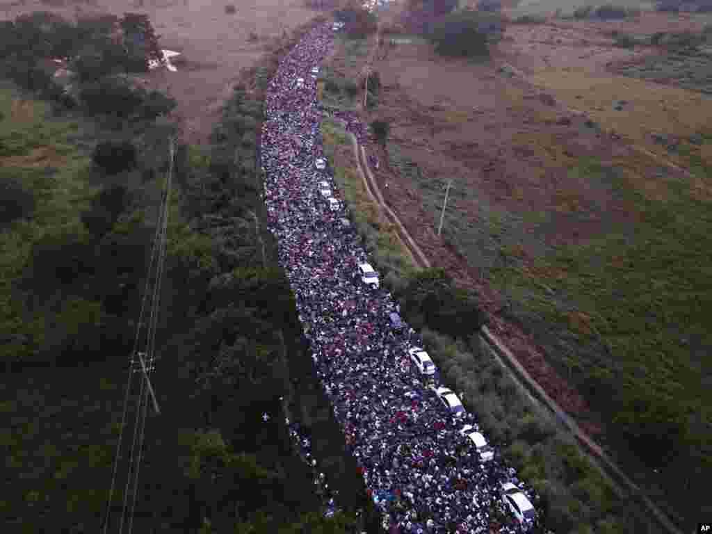 Sebuah kafilah ribuan migran melintasi jembatan antara negara bagian Chiapas dan Oaxaca di Meksiko, setelah polisi Meksiko secara singkat berusaha memblokir mereka di luar kota Arriaga.