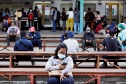 Orang-orang yang memakai masker pelindung duduk pada jam-jam sibuk di stasiun kereta api di tengah wabah COVID-19 di Jakarta, 13 September 2021. (Foto: REUTERS/Ajeng Dinar Ulfiana)