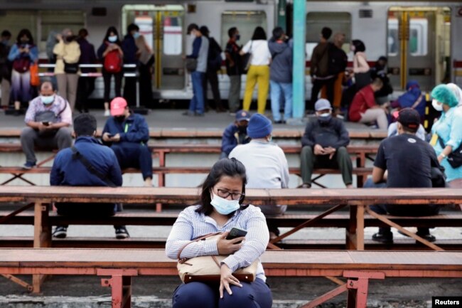 Orang-orang yang memakai masker pelindung duduk pada jam-jam sibuk di stasiun kereta api di tengah wabah COVID-19 di Jakarta, 13 September 2021. (Foto: REUTERS/Ajeng Dinar Ulfiana)