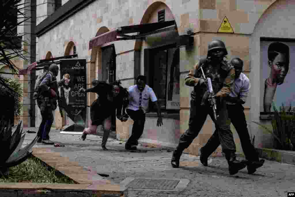 Kenyan security forces help people to escape after a deadly bomb blast and terrorist attack at the Dusit D2 Hotel in Nairobi.