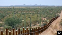 FILE - The international border line made up of bollards separating Mexico, left from the United States, in the Organ Pipe National Monument near Lukeville, Ariz., Feb. 17, 2006.