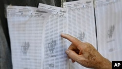 Un hombre busca su número de identificación en una lista de votantes durante un ensayo de votación en la escuela secundaria Andrés Bello en Caracas, el 10 de octubre de 2021.