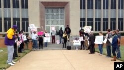 About two dozen people demonstrated outside the Waller County Courthouse in Hempstead, Texas, Jan. 6, 2016.