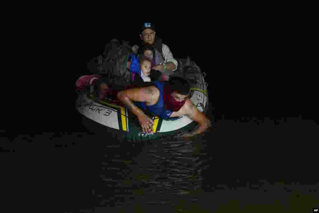 A smuggler takes migrants, mostly from Central American countries, on a small inflatable raft towards U.S. soil in Roma, Texas, March 30, 2021.