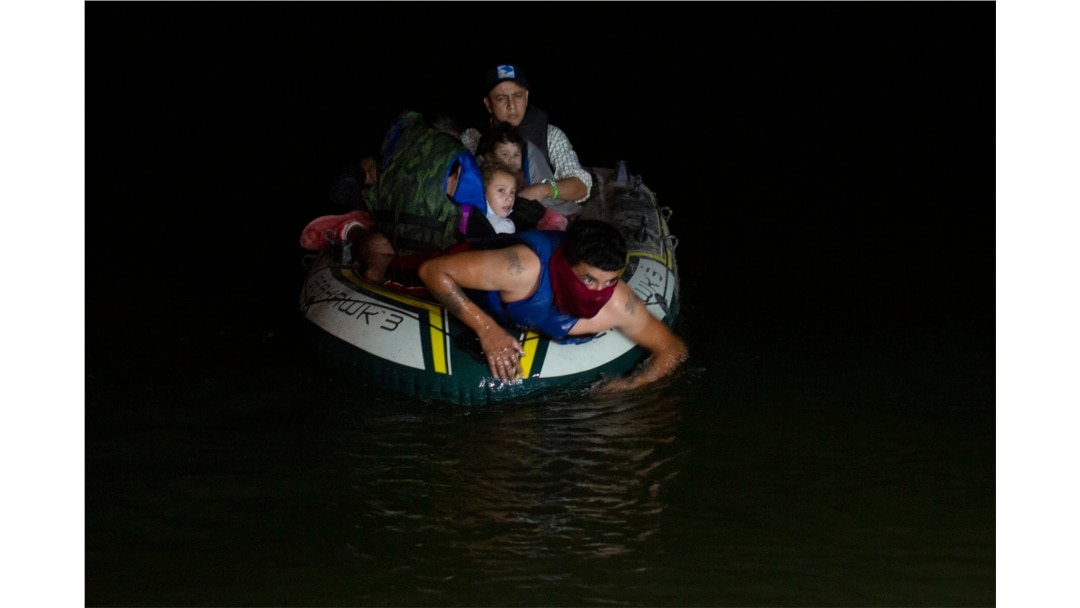A human trafficker takes migrants, mostly from Central American countries, on a small inflatable raft towards U.S. soil in Roma, Texas Tuesday, March 30, 2021.