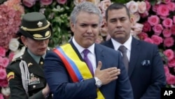 FILE - Colombia's President Ivan Duque gestures after receiving the presidential sash during his inauguration ceremony in Bogota, Colombia, Aug. 7, 2018.