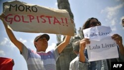 Nesta foto, membros do Grupo Brasil-Mexico, erguem cartazes de apoio a Lula contra a sua prisão, na Praça da Independência na Cidade do México, a 8 de Abril de 2018 
