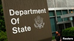 A woman leaves the U.S. State Department building in Washington June 5, 2009. Walter Kendall Myers, a former U.S. State Department official, and his wife Gwendolyn Myers have been arrested for spying for the Cuban government for nearly 30 years, the Justi