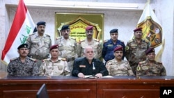A photo shows Iraqi Prime Minister Haider al-Abadi, center, surrounded by top military and police officials as he announces the start of the operation to liberate Mosul, Oct. 17, 2016. Some say Baghdad intends to turn the city into a Shia stronghold.