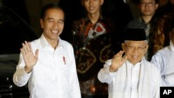 Presiden dan Capres 01 Joko Widodo dan Cawapres 01 Ma'ruf Amin melambai kepada media di di Lanud Halim Perdana Kusuma usai putusan Mahkamah Konstitusi yang memenangkan pasangan Jokowi-Ma'ruf, Kamis malam (27/6). 