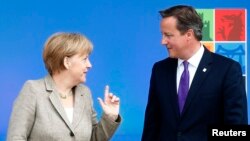 FILE - Britain's Prime Minister David Cameron (R) greets German Chancellor Angela Merkel at the start of the NATO summit at the Celtic Manor resort near Newport in Wales.