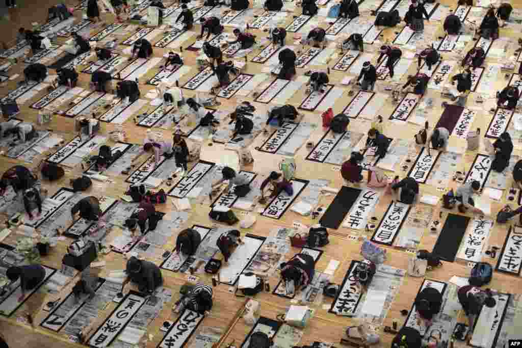 Participants write Japanese calligraphy during the annual New Year calligraphy contest in Tokyo.