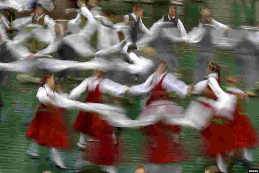 Dancers wear traditional dress as they perform during a students&#39; song and dance festival in Riga, Latvia.