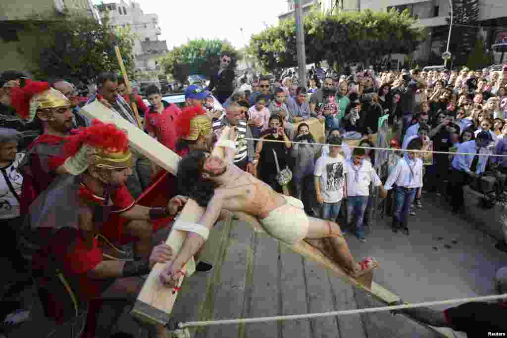 Lebanese Christians take part in a reenactment of the crucifixion of Jesus Christ on Good Friday beside Mar Joseph Chruch, Dhour Sarba, Lebanon, April 18, 2014.&nbsp;