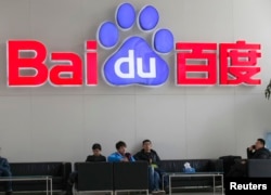 FILE - People sit in front of the company logo of Baidu at its headquarters in Beijing, China, Dec. 17, 2014.