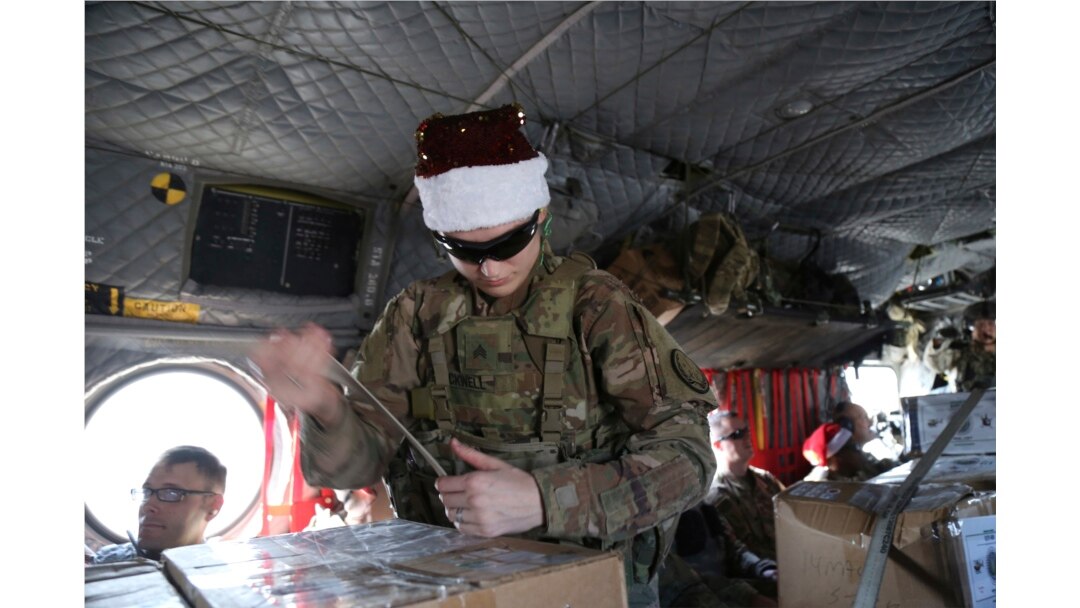 Seorang tentara AS memeriksa hadiah Natal di atas helikopter di Irbil, Irak menuju pangkalan militer AS di Suriah timur, dalam operasi "Holiday Express", Senin, 23 Desember 2019.