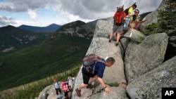 FILE - Day-hikers scramble over rocky boulders on the Appalachian Trail in Maine. 