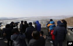 FILE - Visitors use binoculars to see the North Korea side from the unification observatory in Paju, South Korea, Jan. 1, 2018.