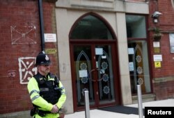 A police officer stands outside Didsbury mosque in Manchester, May 24, 2017.