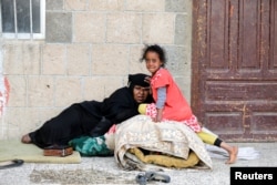 A woman and a girl displaced by the fighting in the Red Sea port city of Hodeida rest at a school where internally displaced people live in Sanaa, Yemen, June 26, 2018.