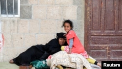 A woman and a girl displaced by the fighting in the Red Sea port city of Hodeida rest at a school where internally displaced people live in Sanaa, Yemen, June 26, 2018.