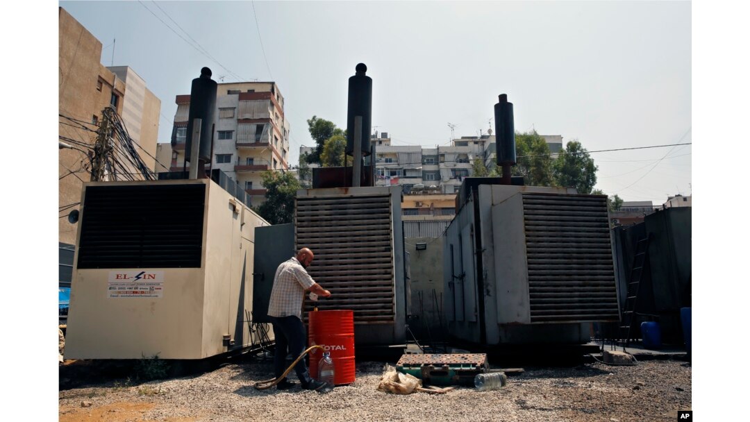 This July 16, 2018, photo shows Mamdouh al-Amari oiling privately-owned diesel generators that provide power to homes and businesses, in the southern suburbs of Beirut, Lebanon.