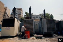 This July 16, 2018, photo shows Mamdouh al-Amari oiling privately-owned diesel generators that provide power to homes and businesses, in the southern suburbs of Beirut, Lebanon.
