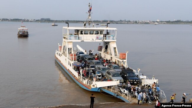 FILE - Passengers disembark from a ferry in Phnom Penh on March 3, 2020.