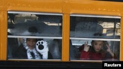 Children from Sandy Hook Elementary School make their way to their new school in Monroe as they leave Newtown, Connecticut, January 3, 2013.